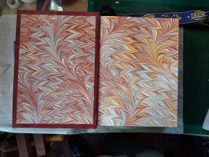 Open Roman Missal showing hand marbled end papers in red yellow and blue