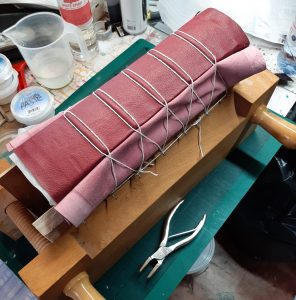 book in a finishing press tied up with string to bring up the bands with band nippers