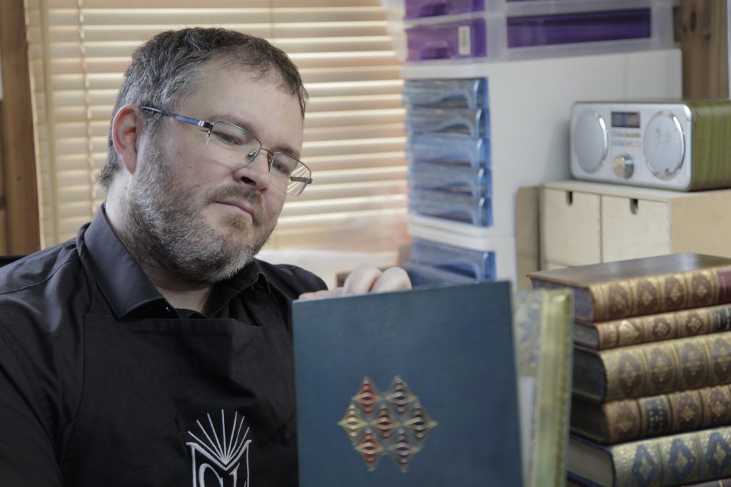 Bookbinder examining a fine binding