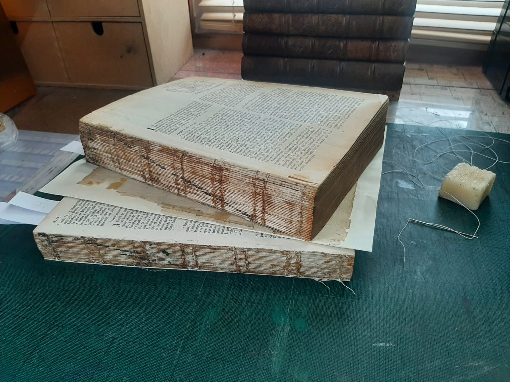Spanish Bible split in half with wax and thread in the background