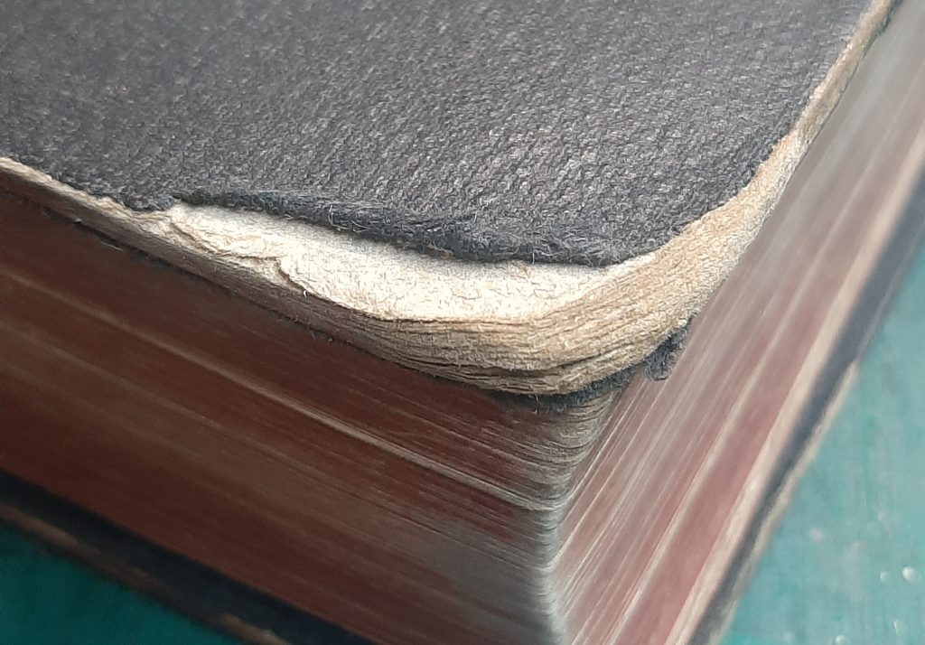 Delaminated corner of hardback book, separating out into layers